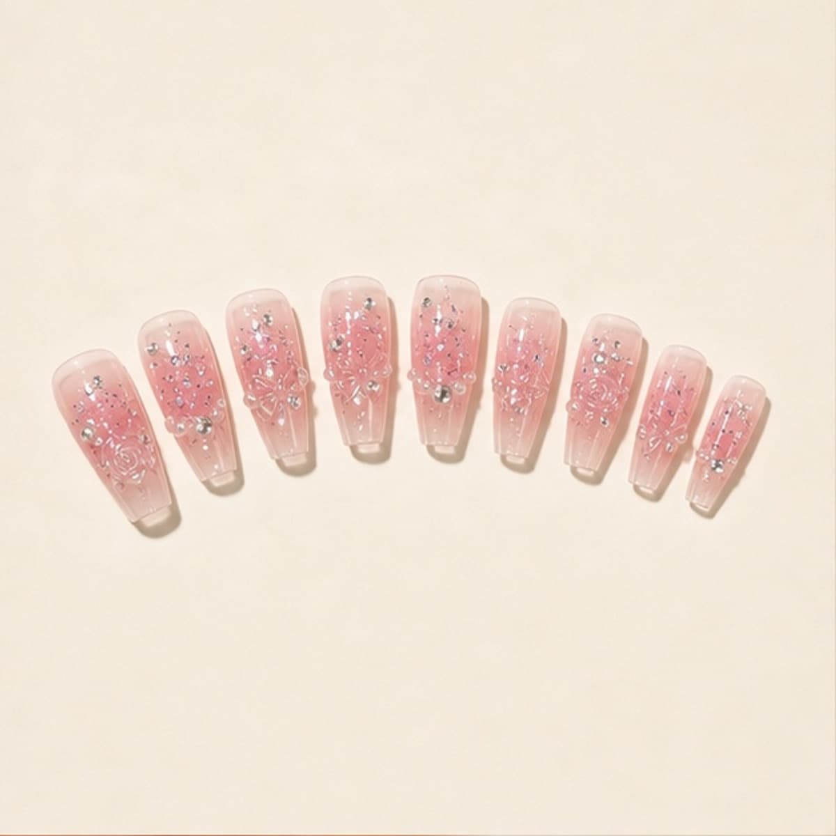 Camélia rose crystal ballet press-on nail set arranged in a fan on an ivory background