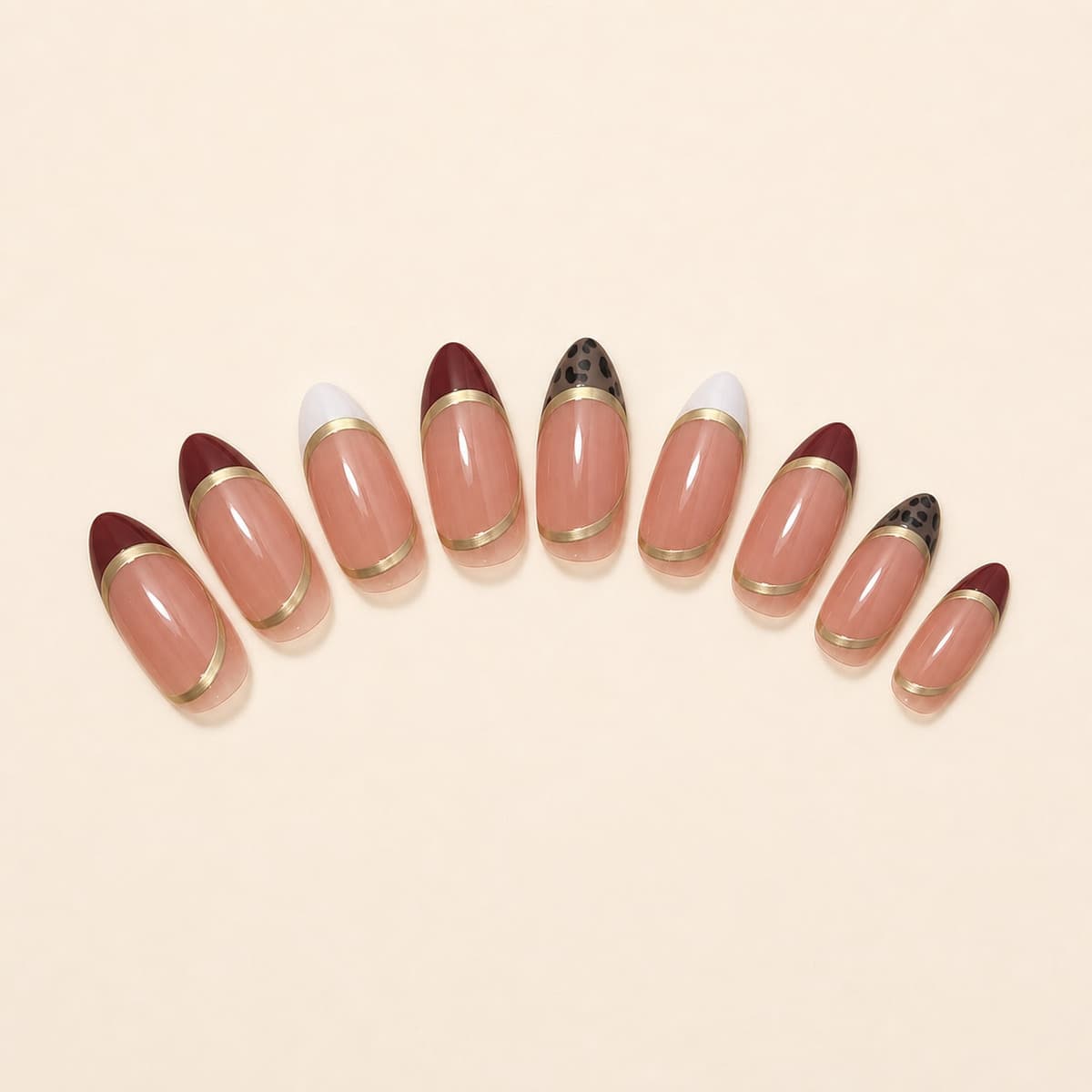 Duchesse brown, ivory and gold French press-on nail set arranged in a fan on an ivory background