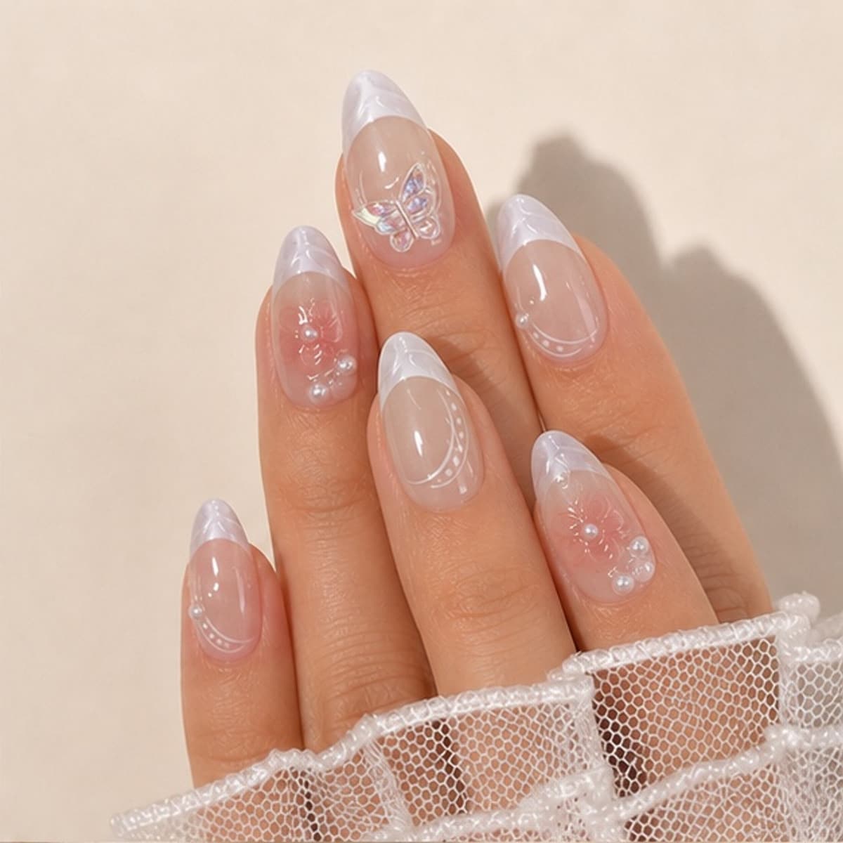 Fleur butterfly garden French press-on nails worn on a relaxed hand against a cream background