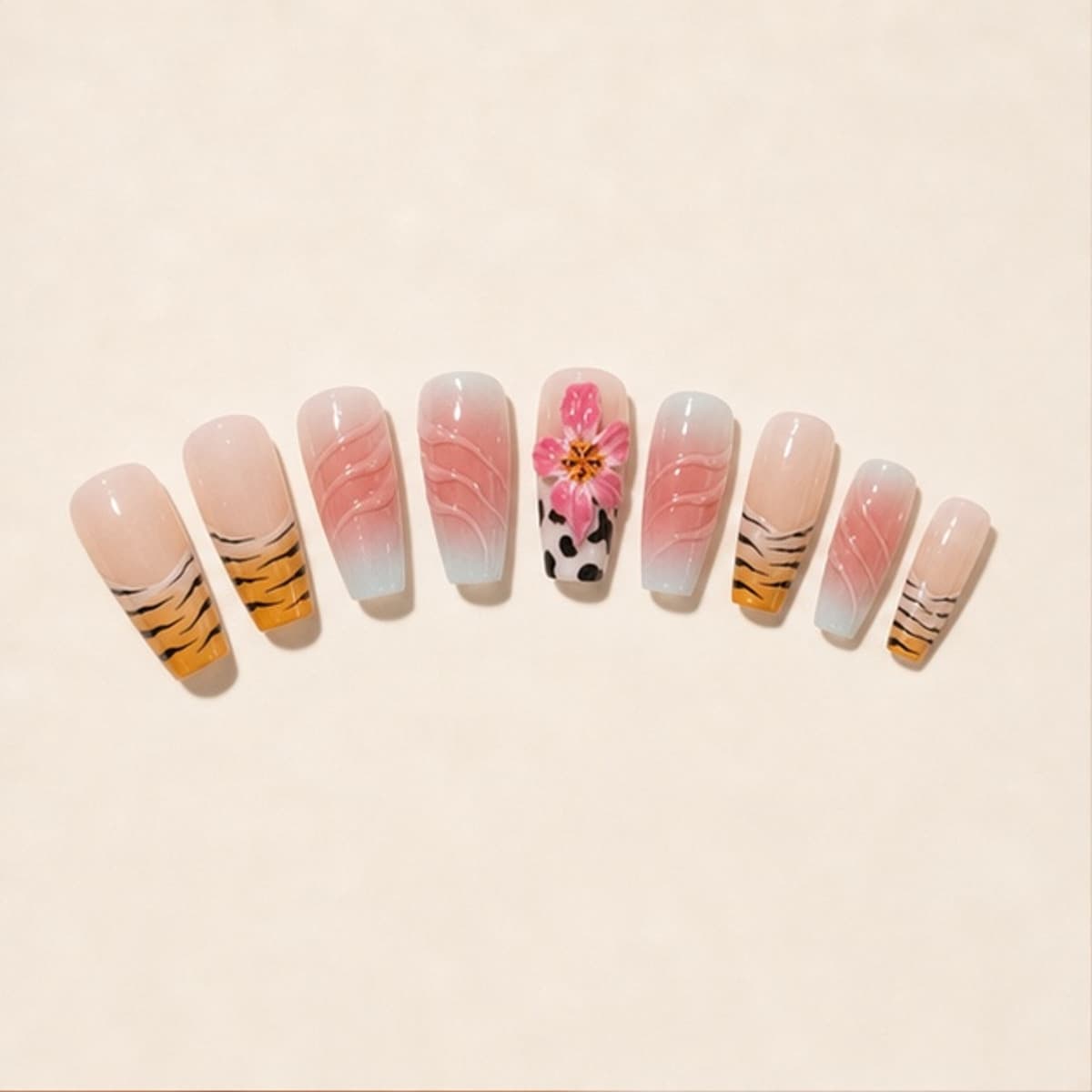 Héritage sculpted lily and zebra press-on nail set arranged in a fan on an ivory background