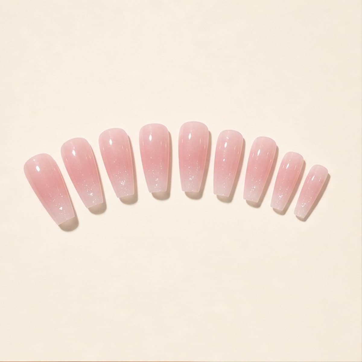 Nacre blush shimmer press-on nail set arranged in a fan on an ivory background