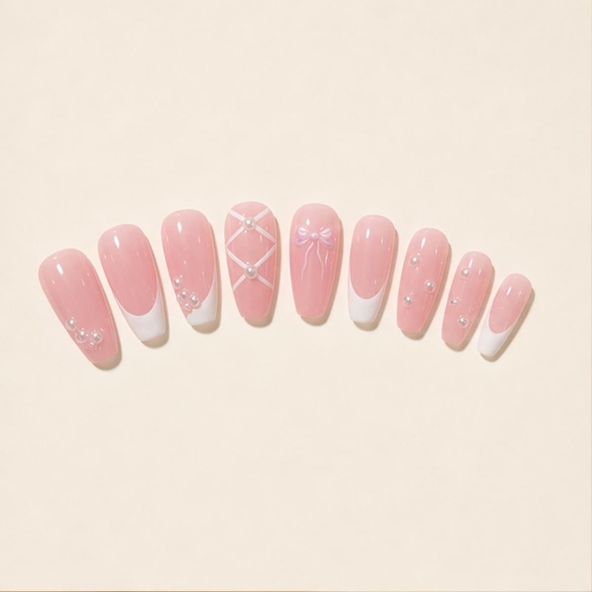 Opaline short hand-painted pink French press-on nail set arranged in a fan on an ivory background